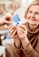 Frau fügt Puzzleteile zusammen